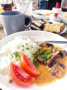 a plate of food with rice and meat and tomatoes at Karakol Yurt Lodge in Karakol