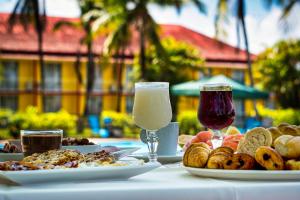 ein Tisch mit Tellern mit Essen und Gläsern Wein in der Unterkunft L'Hôtel Du Fleuve in Sinnamary