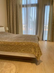 a bedroom with a bed and a large window at Hawana Palm Beach in Salalah