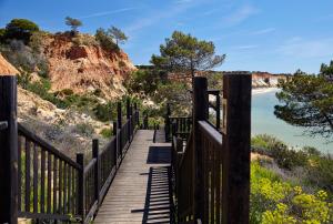 a wooden boardwalk leading down to the beach at PortoBay Falesia in Albufeira
