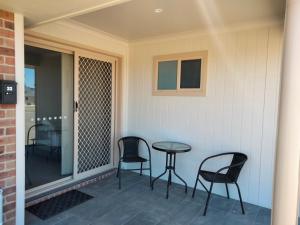 a patio with chairs and a table on a porch at Stockmans Motel in Tamworth