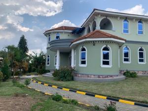 uma grande casa azul sentada em cima de um quintal em Ishuro Villas em Rukungiri