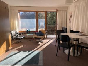 a living room with chairs and a table and a window at Casa Marlenca in Arosa