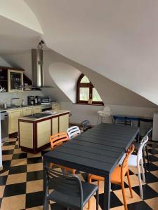 une cuisine avec une table et des chaises noires dans l'établissement Szines Panoráma Apartman, à Balatonlelle