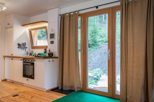 a kitchen with a sliding glass door leading to a patio at WOHNWAGON Tiny Houses I in Gutenstein