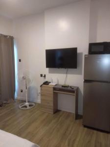 a room with a refrigerator and a desk with a television at Antara Residential Condominium in Talisay