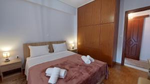 a bedroom with a bed with two towels on it at Makarios Apartment Near Athens Aiport in Spata