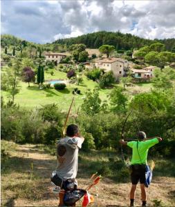 two men are standing with arrows in a field at Poderi Val Verde in Castellina in Chianti
