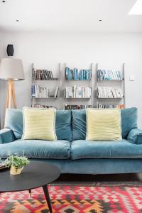 a blue couch in a living room with bookshelves at The Oaks, Twyford Moors, South Downs National Park in Winchester