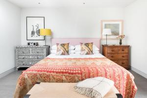 a bedroom with a large bed with a colorful blanket at The Oaks, Twyford Moors, South Downs National Park in Winchester