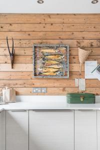 a kitchen with a wooden wall with a painting on it at The Oaks, Twyford Moors, South Downs National Park in Winchester