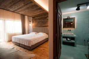 a bedroom with a bed and a mirror and a shower at HANUL BUCOVINEI in Câmpulung Moldovenesc