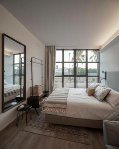 sypialnia z dużym łóżkiem i dużym oknem w obiekcie Apartamentos Rosa Velázquez w Meridzie