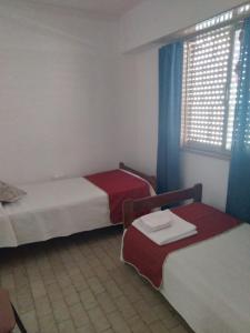 een kamer met 2 bedden en een raam met gordijnen bij La estacion in Tandil