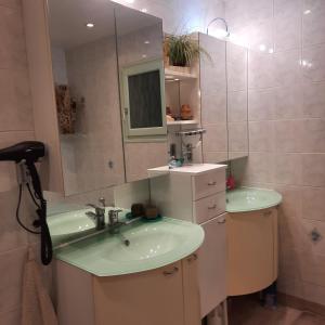 ein Badezimmer mit 2 Waschbecken und einem Spiegel in der Unterkunft REVES BLEUS in Crans