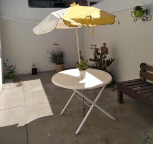 a white table with an umbrella and some plants at La estacion in Tandil