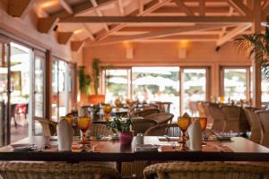 a dining room with tables and chairs and windows at PortoBay Falesia in Albufeira