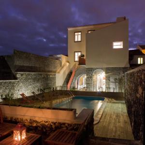 a villa with a swimming pool at night at Azorean Urban Lodge in Ponta Delgada