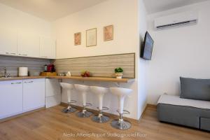 a kitchen with a bar and a couch in a room at Nesto Athens Airport Zen in Spata
