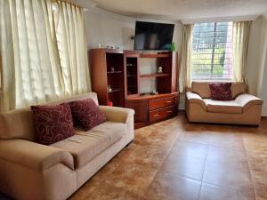 sala de estar con sofá y silla en Quitumbe - Moderno y cómodo departamento, en Quito