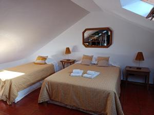 a bedroom with two beds and a mirror at Valmoa in Praia da Vitória
