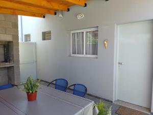una mesa y sillas en un patio con puerta en Cholito 2 en Alta Gracia