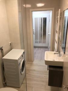 ein Badezimmer mit einer Waschmaschine und einem Waschbecken in der Unterkunft Hochfeld Apartment in Augsburg in Augsburg