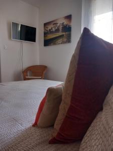 a bedroom with a bed with two pillows and a television at Appartement Le Louvre in Dijon