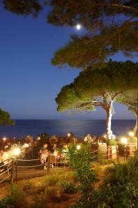 a group of people standing around at night at PortoBay Falesia in Albufeira