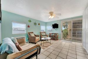 a living room with a couch and a tv at The Seashell Suite with Private Balcony and Walk to Beach in Clearwater Beach