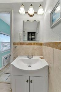 a bathroom with a white sink and a mirror at The Seashell Suite with Private Balcony and Walk to Beach in Clearwater Beach