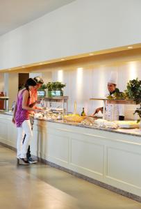a group of people in a kitchen preparing food at PortoBay Falesia in Albufeira