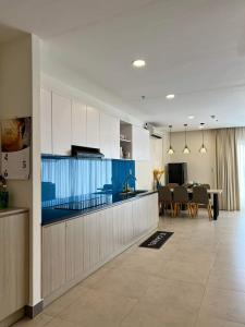 Căn hộ Aria Resort Vũng Tàu 3 Phòng ngủ في Xã Thắng Nhứt: مطبخ وغرفة طعام مع خزائن زرقاء وبيضاء
