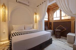 Schlafzimmer mit einem großen weißen Bett und einem Fenster in der Unterkunft Riad Jenan L'mouassine in Marrakesch