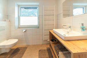 a bathroom with a sink and a toilet and a window at Stöcklhof in Pettneu am Arlberg