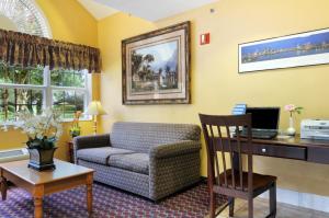 a living room with a couch and a desk at Hometown Inn & Suites Jacksonville Butler Blvd./Southpoint in Jacksonville