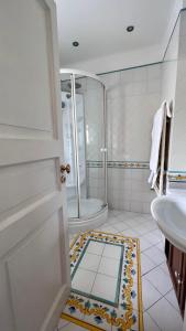 uma casa de banho com um chuveiro, um lavatório e uma porta em Calabritto Suite em Nápoles