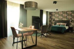 um quarto com uma cama, uma mesa e cadeiras em Hotel Studio SIS em Steenbergen