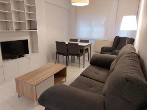uma sala de estar com um sofá e uma mesa em Apartamento Oteiza em San Sebastián