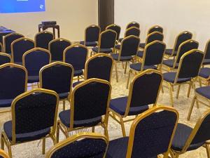 une rangée de chaises avec des fauteuils bleus et or dans l'établissement Fahrenheit Apartments, à Abuja