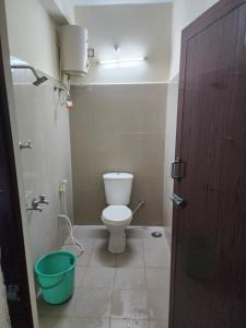 ein Badezimmer mit einem WC und einem grünen Eimer in der Unterkunft Raja Rani Mahal Ac-Rooms in Tiruvannāmalai