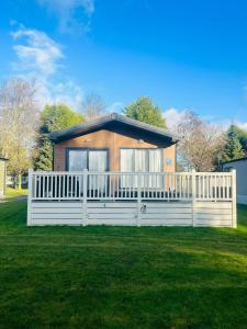a house with a white fence in a yard at Bushmills Lodge with Hot Tub in Thornton
