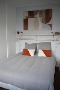 1 dormitorio con 1 cama blanca y 2 almohadas en Le Cocon de Nacre - à 300m de la plage - wifi en Courseulles-sur-Mer