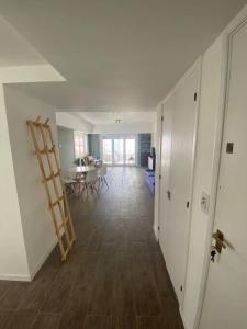 a hallway with a room with a table and a ladder at Departamento 3 ambientes vista al mar en Playa Grande con cochera cubierta in Mar del Plata