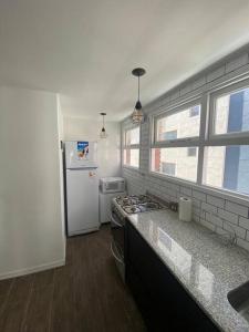 a kitchen with a stove and a refrigerator at Departamento 3 ambientes vista al mar en Playa Grande con cochera cubierta in Mar del Plata