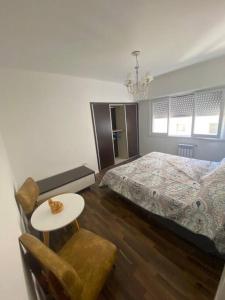 a bedroom with a bed and a table and a chair at Departamento 3 ambientes vista al mar en Playa Grande con cochera cubierta in Mar del Plata