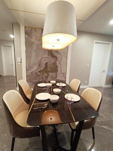 a black dining room table with chairs and a light fixture at Platinum 2 KLCC NewLuxuryCondo By Langitel with InfinityCityView SwimmingPool in Kuala Lumpur
