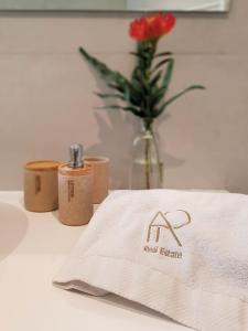 un tavolo con un asciugamano e un vaso con un fiore di AR Boutique Apartments a Bergamo