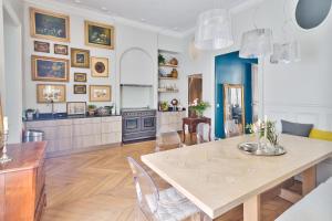 a kitchen and dining room with a table and chairs at Appartement de standing sur l'île Saint-Louis by Weekome in Paris
