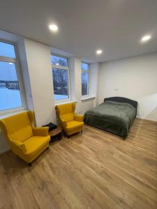 - une chambre avec un lit et deux chaises jaunes dans l'établissement Airport lux apartment 30 Self Check-In Free Parking, à Vilnius